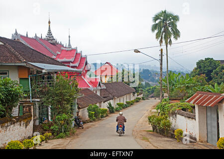 Équitation motard passé temple bouddhiste dans la ville Keng Tung / Kengtung, Shan State, Myanmar / Birmanie Banque D'Images