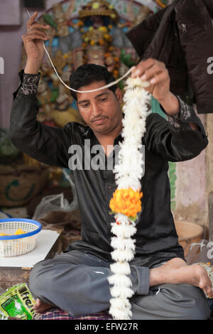 Jodhpur, Rajasthan, Inde. L'enfilage des guirlandes de fleurs fleuriste à vendre dans le bazar Banque D'Images