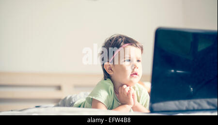 Petite fille regarder les dessins animés à l'ordinateur portable Banque D'Images