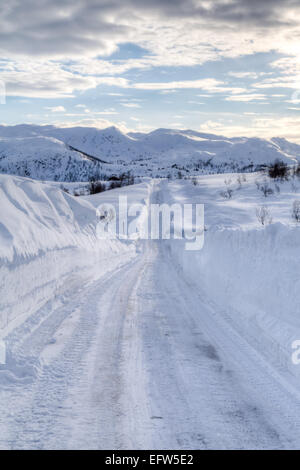 Photo d'une route couverte de neige, avec des montagnes à l'arrière Banque D'Images