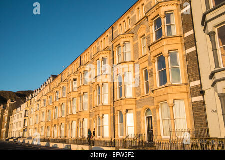 Maisons en terrasse le long de Victoria,terrasse avec vue sur la plage et la baie de Cardigan au coucher du soleil, Aberystwyth, Ceredigion, pays de Galles, Pays de Galles. Banque D'Images