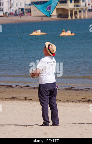 Homme volant cerf-volant au Weymouth Kite Festival, Dorset, Royaume-Uni, en mai Banque D'Images