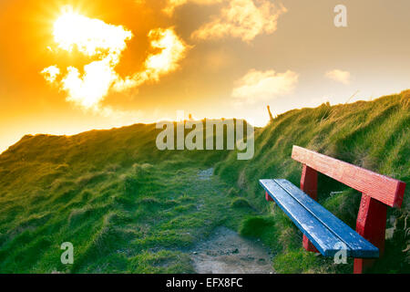 Banc sur une falaise avec vue sur la côte et la plage de Ballybunion au coucher du soleil Banque D'Images