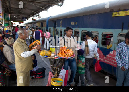 Vendeur de rue est préparation des papayes pour les vendre aux voyageurs d'une gare à Gaya Bihar Banque D'Images