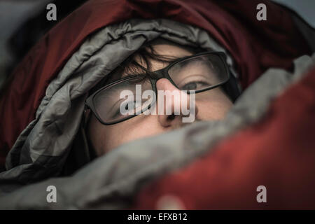 Portrait de jeune homme à capuchon en camping-sac de couchage, Alpes bavaroises, Oberstdorf, Bavière, Allemagne Banque D'Images