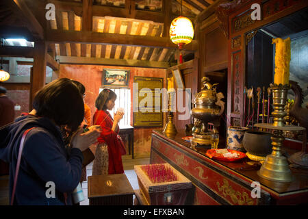 Les gens priant au culte à l'intérieur du pont couvert japonais, Hoi An, Vietnam. Banque D'Images