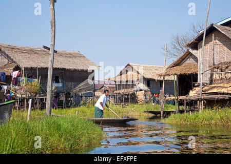 Dans l'homme ethnie Intha proa au village traditionnel avec des maisons sur pilotis en bambou dans le lac Inle, Nyaungshwe, Shan State, Myanmar / Birmanie Banque D'Images