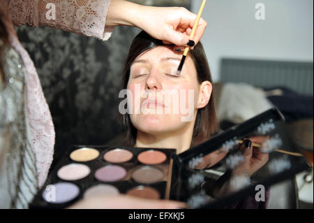 Artiste de maquillage Ombre à paupières s'applique à une dame. Banque D'Images