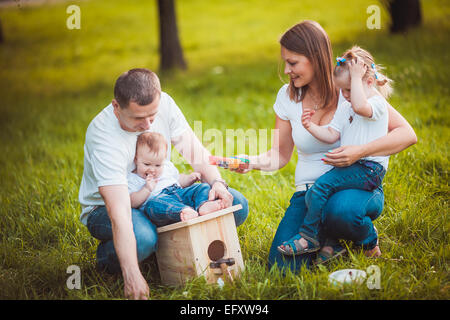 Famille heureuse avec nichoir et peintures Banque D'Images