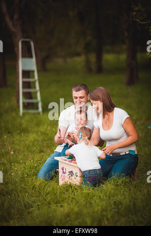 Famille heureuse avec nichoir et peintures Banque D'Images