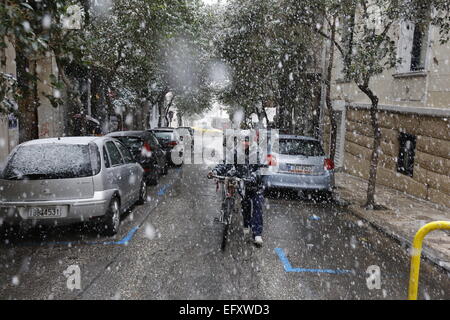 Athènes, Grèce. Feb 11, 2015. Un homme pousse une moto à travers la neige à Athènes. Après des semaines de printemps comme la météo, la neige est arrivée à Athènes pour un court moment. Crédit : Michael Debets/Pacific Press/Alamy Live News Banque D'Images