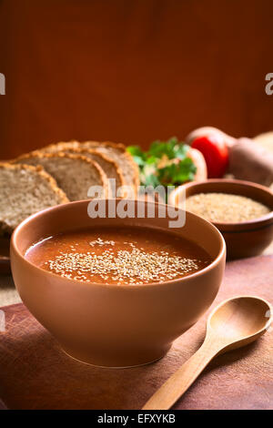 Crème de légumes soupe de tomate, carotte, pomme de terre et le persil servi dans un bol et parsemer de graines de sésame Banque D'Images