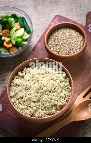 Coup de frais généraux les graines de quinoa blanc cuit dans un bol avec les graines de sésame et de légumes frits dans l'arrière photographié avec lumière naturelle Banque D'Images