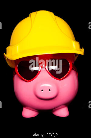 Piggy Bank wearing hard hat fond noir Banque D'Images