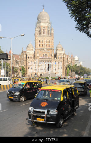 Mumbai, Inde - 5 janvier 2015 : Les gens de se mettre sur le taxi en face d'un bâtiment colonial à Mumbai, Inde Banque D'Images