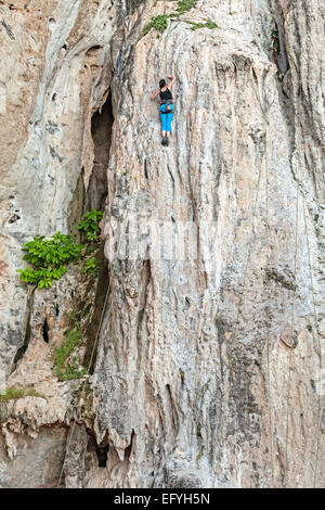 Young female rock climber, concept pour le saut à travers des cerceaux. Banque D'Images