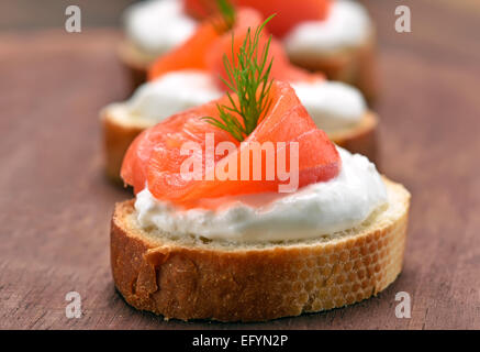 Sandwiches au saumon sur planche à découper en bois, vue en gros Banque D'Images