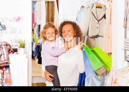 Fille avec happy mother holding shopping sac Banque D'Images