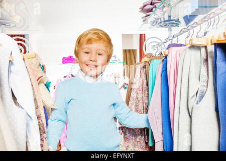 Happy blonde boy laughing in shopping mall Banque D'Images