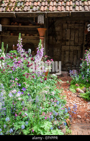 Abri de jardin avec chemin fait de pièces en terre cuite cassée et plantation cottage garden Banque D'Images