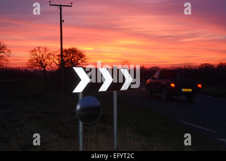 Au coucher du soleil du véhicule panneau d'avertissement de passage de virage et de sécurité circulaire miroir pour donner aux conducteurs de voir road uk Banque D'Images