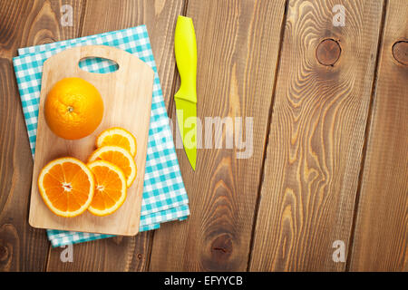 Orange en tranches sur une planche à découper. Vue de dessus plus table bois contexte with copy space Banque D'Images