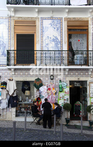 Les touristes assis à l'extérieur d'un café dans le tourisme populaire Alfama de Lisbonne au Portugal Banque D'Images