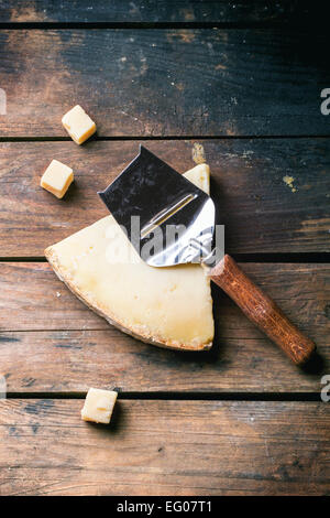 Gros morceau et de petits cubes de fromage avec du fromage belge à couteau sur fond de bois. Vue d'en haut. Banque D'Images