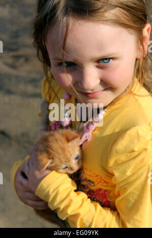 Image de petite fille avec chaton rouge Banque D'Images