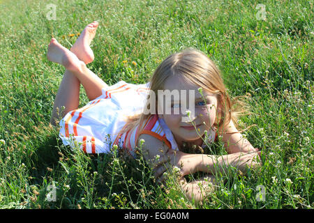 À la mode little girl lying on the Green grass Banque D'Images