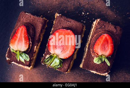 Gâteau au chocolat tiramisu aux fraises sur ardoise noire, vue du dessus Banque D'Images