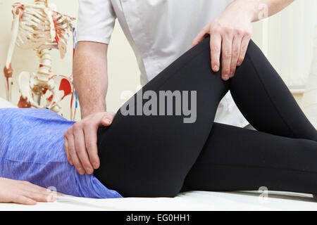 Ostéopathe Mâle Femelle Traitement Patient avec problème de hanche Banque D'Images