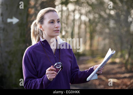 Course d'orientation dans les bois avec femme la carte et boussole Banque D'Images
