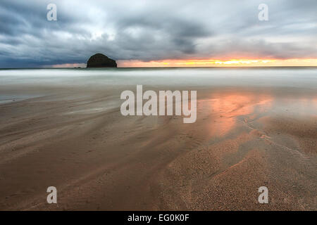 Royaume-uni, Angleterre, Cornouailles, Trebarwith Strand, les nuages de tempête au-dessus de l'île de silhouette sur l'horizon de mer Banque D'Images