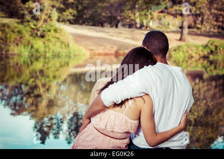 Vue arrière d'un couple assis près d'un lac, Californie, États-Unis Banque D'Images