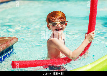 Jeune garçon (6-7) playing in swimming pool