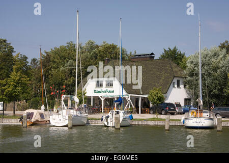 Yachts sur le Darß dans la marina de Ahrenshoop Althagen typique contre les hangars à bateaux Banque D'Images