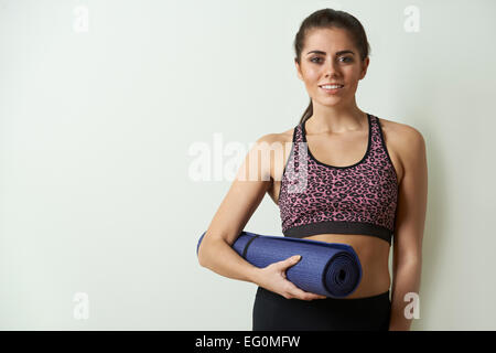 Jeune femme dans les vêtements de sport Tapis d'exercice comptable Banque D'Images