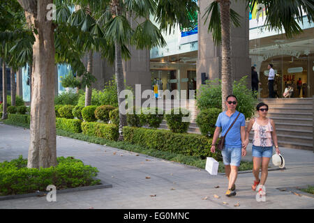 Couple en train de marcher à l'extérieur centre Vincom, Ho Chi Minh City, Vietnam Banque D'Images