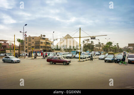 Le Caire, Égypte, janvier 2015 - intersection achalandée avec une pyramide à l'arrière-plan Banque D'Images