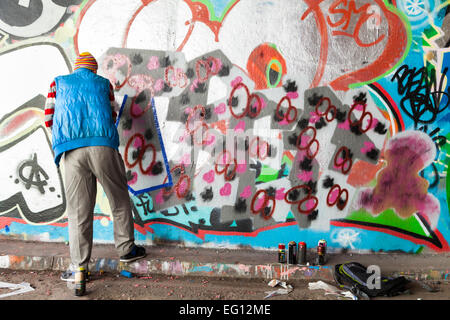 Artiste de rue au travail à 'Le Tunnel', une zone graffiti autorisé à Leake Street près de la gare de Waterloo à Londres Banque D'Images