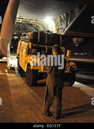 Le s.. Lynzey Thorton, 41e Escadron de transport aérien l'arrimeur, guides d'un Humvee à l'arrière d'un C-130J Le 14 janvier à l'Aéroport International de Biloxi-Gulfport, au Mississippi, dans le cadre de leur mission de fournir l'équipement et du personnel pour appuyer les efforts de secours en Haïti. L'avion lancé à partir de la Base aérienne de Little Rock, Ark., près de minuit le 13 janvier, chargé du personnel et des équipements avant l'aube à l'Aéroport International de Biloxi-Gulfport, au Mississippi, et les a livrées à l'Aéroport International de Port-au-Prince, Haïti, le matin du 14 janvier. Le personnel de l'USAF Photo par le Sgt. Tchad Chisholm Banque D'Images