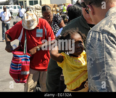 U.S. Air Force, le Lieutenant-colonel Joseph Pocreva 1re Escadre d'opérations spéciales, de l'Air Force Special Operations Command, parle d'une jeune Haïtienne à peu à l'Troussaint Louverture, aéroport, Haïti, avant qu'elle est évacuée vers les États-Unis. Haïti a été dévasté par un tremblement de terre dans la capitale Port-au-Prince. par Master Sgt. Russell E. Cooley IVReleased Banque D'Images