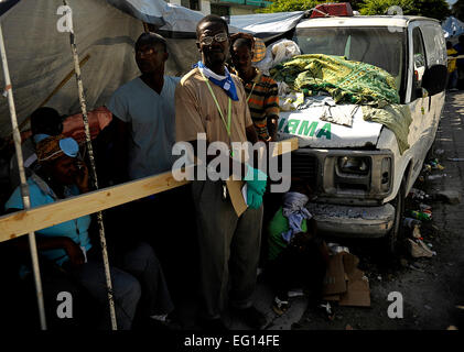 Bien que l'ancien président américain Bill Clinton visite l'Hôpital général de Port-au-Prince, en Haïti, les habitants se rassemblent à l'extérieur pour voir l'ancien président, le 18 janvier 2010. Comme l'envoyé spécial américain en Haïti, le Président Clinton a sondé les efforts de secours et de dommages causés par le tremblement de terre le 12 janvier 2010. par Master Sgt. Russell E. Cooley IVReleased Banque D'Images