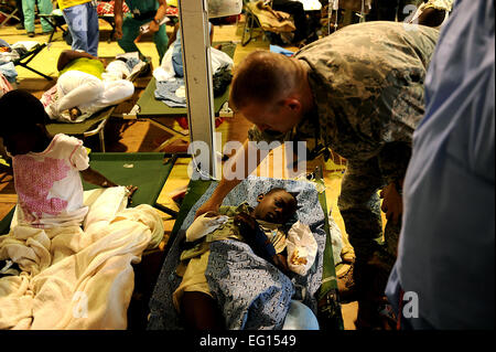 U.S. Air Force Orthopédiste Major Thomas Bled, 96e SGOS, Eglin AFB, Floride, écrans tremblement de patients à l'Université de Miami medical tentes à l'aéroport international Toussaint Louverture, Port-au-Prince, Haïti le 25 janvier 2010 lors de l'opération réponse unifiée. Les médecins sont 27 Dépistage de patients d'être évacué sur un C-17 à l'Aéroport International de Miami, Fort Lauderdale, FL. Ministère de la défense d'actif ont été déployés dans le but d'aider à l'effort de secours en Haïti après un séisme de magnitude 7 qui a frappé la ville le 12 janvier 2010. Le sergent-chef. Jeremy Lock Rel Banque D'Images