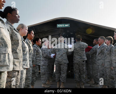 Les membres du 332e Groupe médical expéditionnaire Color Guard déplier un nouveau drapeau tout en le plaçant dans sa juste place dans la Route du héros, 1 septembre 2010, Joint Base Balad, de l'Iraq. "C'est le moment idéal pour changer le drapeau comme notre accent change également," a déclaré le Colonel Mitchell. "Nous avons pris le pavillon liés aux opérations de combat et de la manière dont les choses étaient. Nous nous concentrons maintenant sur 'Former les formateurs', que nous formons et tournez le contrôle à l'armée iraquienne en préparation pour le 31 décembre 2011." Senior Airman Marianne E. Lane Banque D'Images