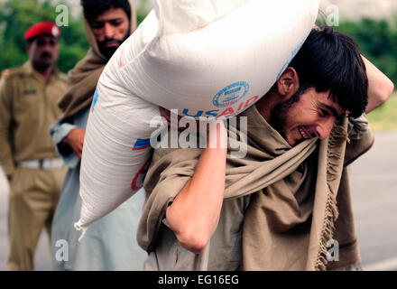 Un groupe d'Pakastani locaux aider les Marines des États-Unis en déchargeant des centaines de sacs de farine à bord d'un KC-130J Super Hercules affecté à la 352VMGR après son arrivée à la base aérienne de Gilgit, Pakistan, le 8 septembre 2010. Le s.. Andy M. Kin Banque D'Images