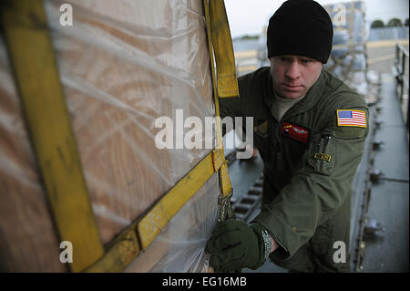 Le personnel de l'US Air Force. Le Sgt. Blake Landry, un C-130 Hercules de l'arrimeur, 36e Escadron de transport aérien à Yokota Air Base, Japon, guides cargo dans son avion pour le transport de Misawa Air Base, au Japon, à l'appui de l'opération Tomodachi. Dans le cadre de l'opération Tomodachi, l'armée des États-Unis a placé les capacités d'aide humanitaire dans la région touchée par le soutien aux efforts de secours d'urgence à la demande du gouvernement du Japon. Tech. Le Sgt. DeNoris A. Monkeybone Banque D'Images