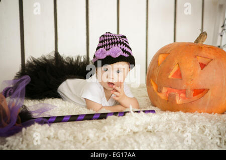 Belle fille avec le syndrome de pensivement garde doigt dans la bouche près de la big pumpkin Banque D'Images