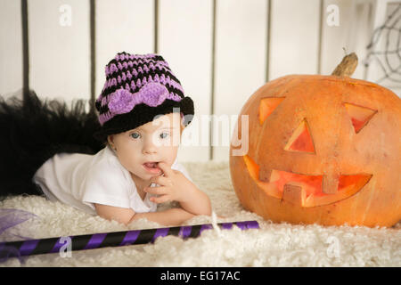 Belle fille avec le syndrome de pensivement garde doigt dans la bouche près de la big pumpkin Banque D'Images